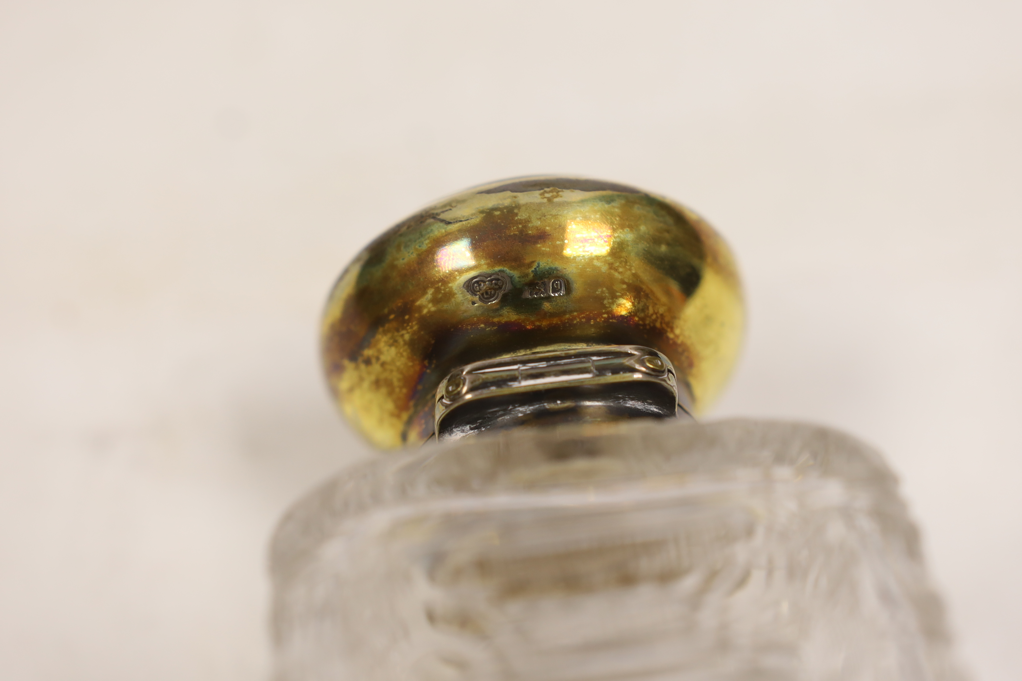 A pair of George V silver gilt mounted cut and etched glass square scent bottles and stoppers, Goldsmiths & Silversmiths Co Ltd, London, 1911, 15cm.